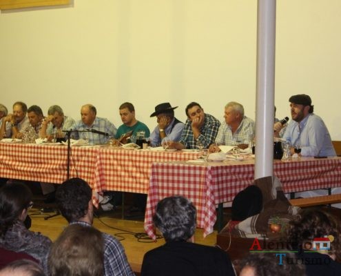 Homens a cantar, a comer e beber.