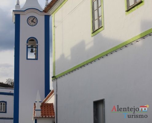 Torre da igreja e casa tradicional com barras verde