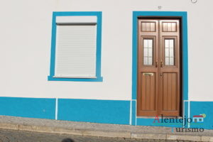 Porta castanha em casa com janela e barra azul