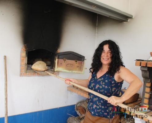 Pão a ser retirado do forno com pá de madeira