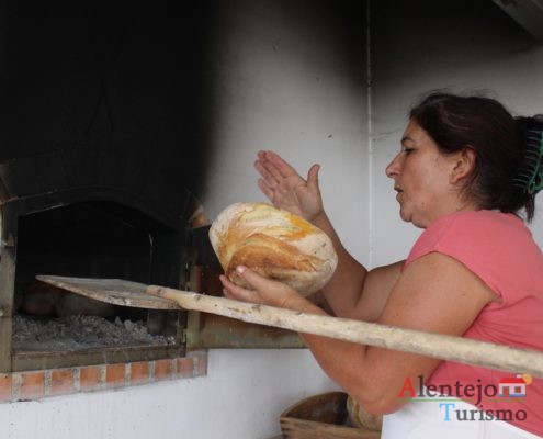 Mulher a retirar pão do forno