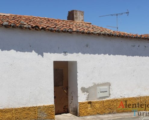 Casa com porta castanha e barra amarela.